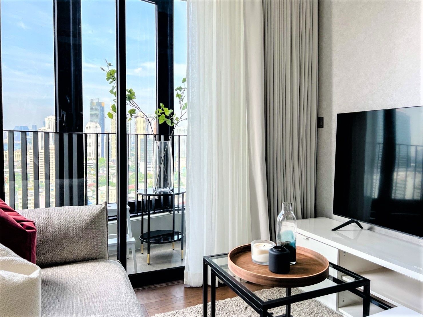 Living room with balcony, city view, and modern decor.